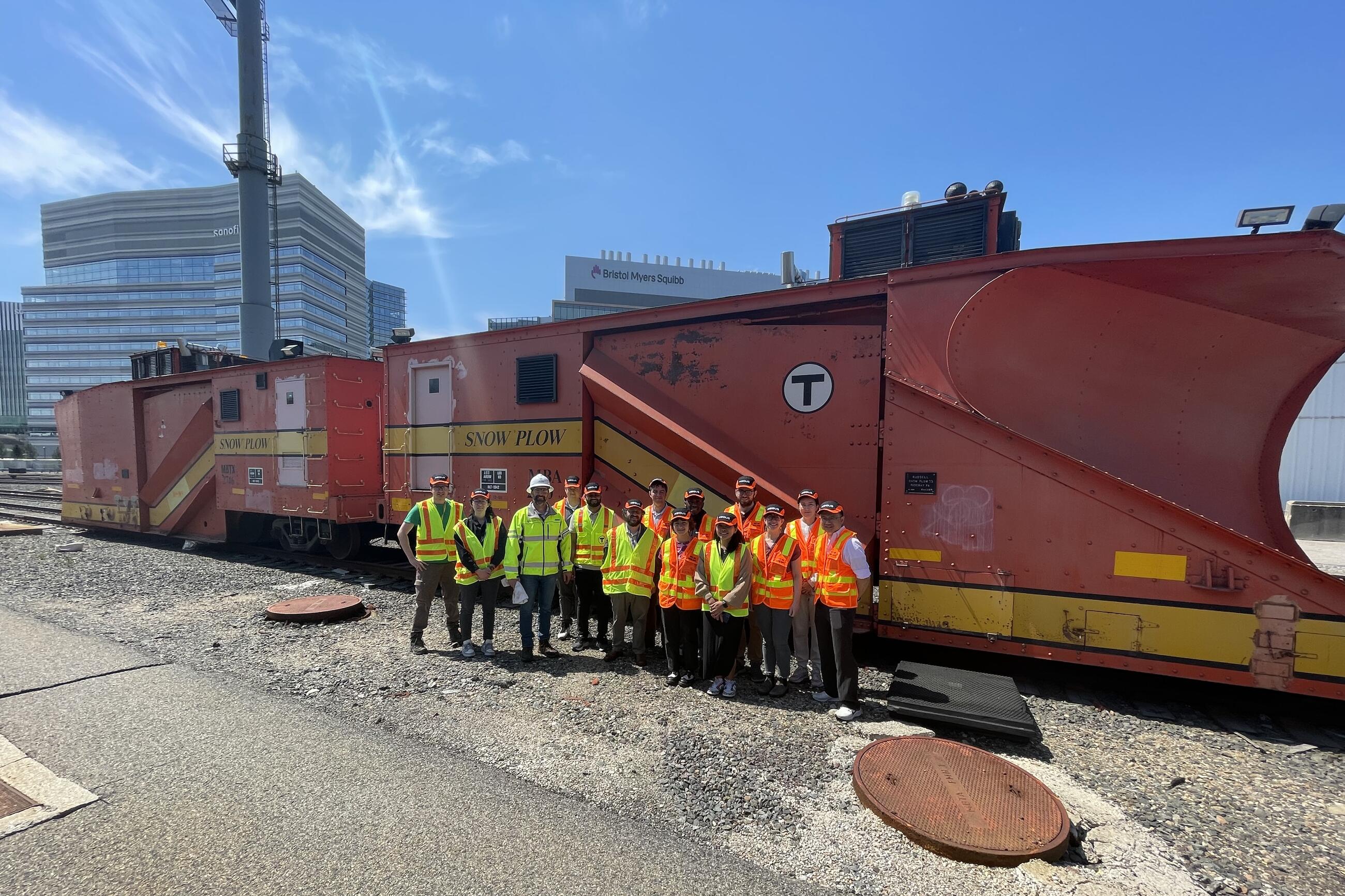 A group of interns in neon safety vests poses for a group photo