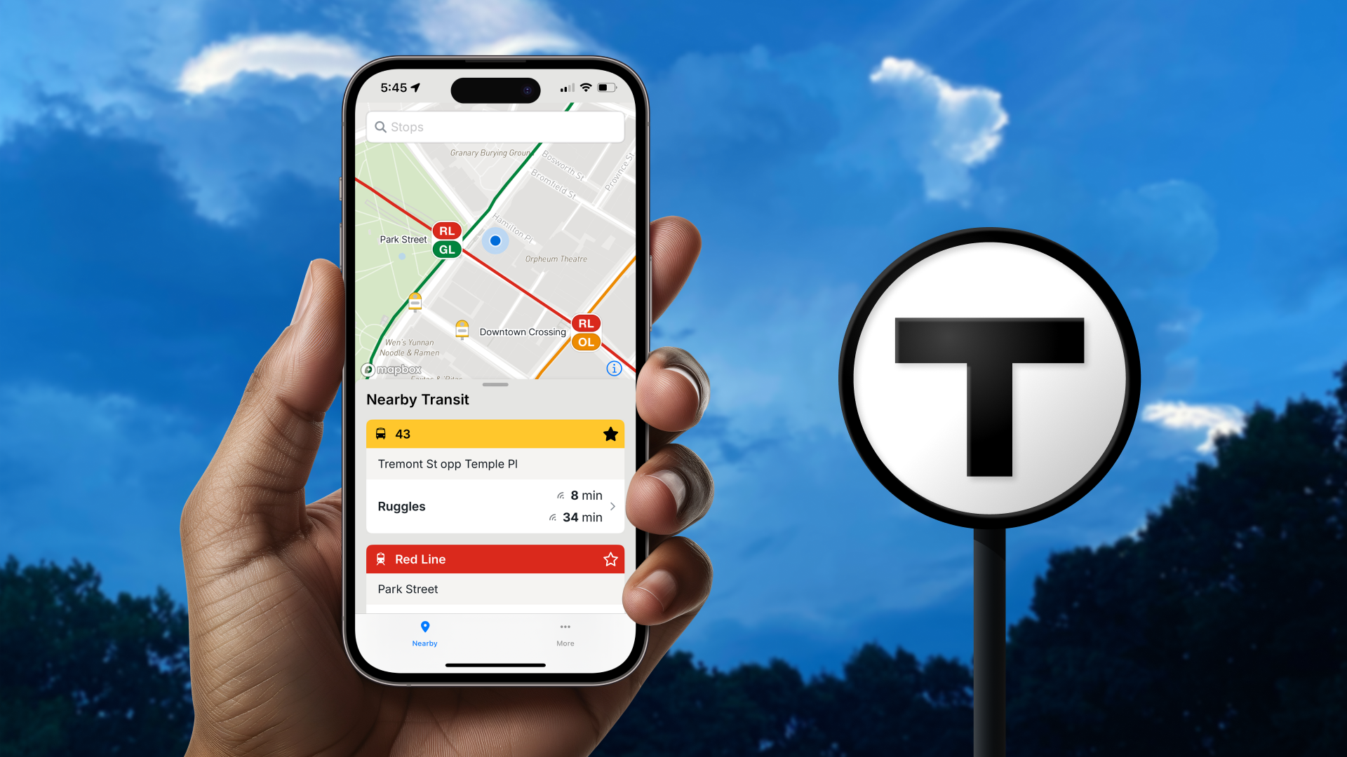 Hand holding an iPhone open to the MBTA Go mobile app, showing live arrival times for nearby Buses and Red Line vehicles.