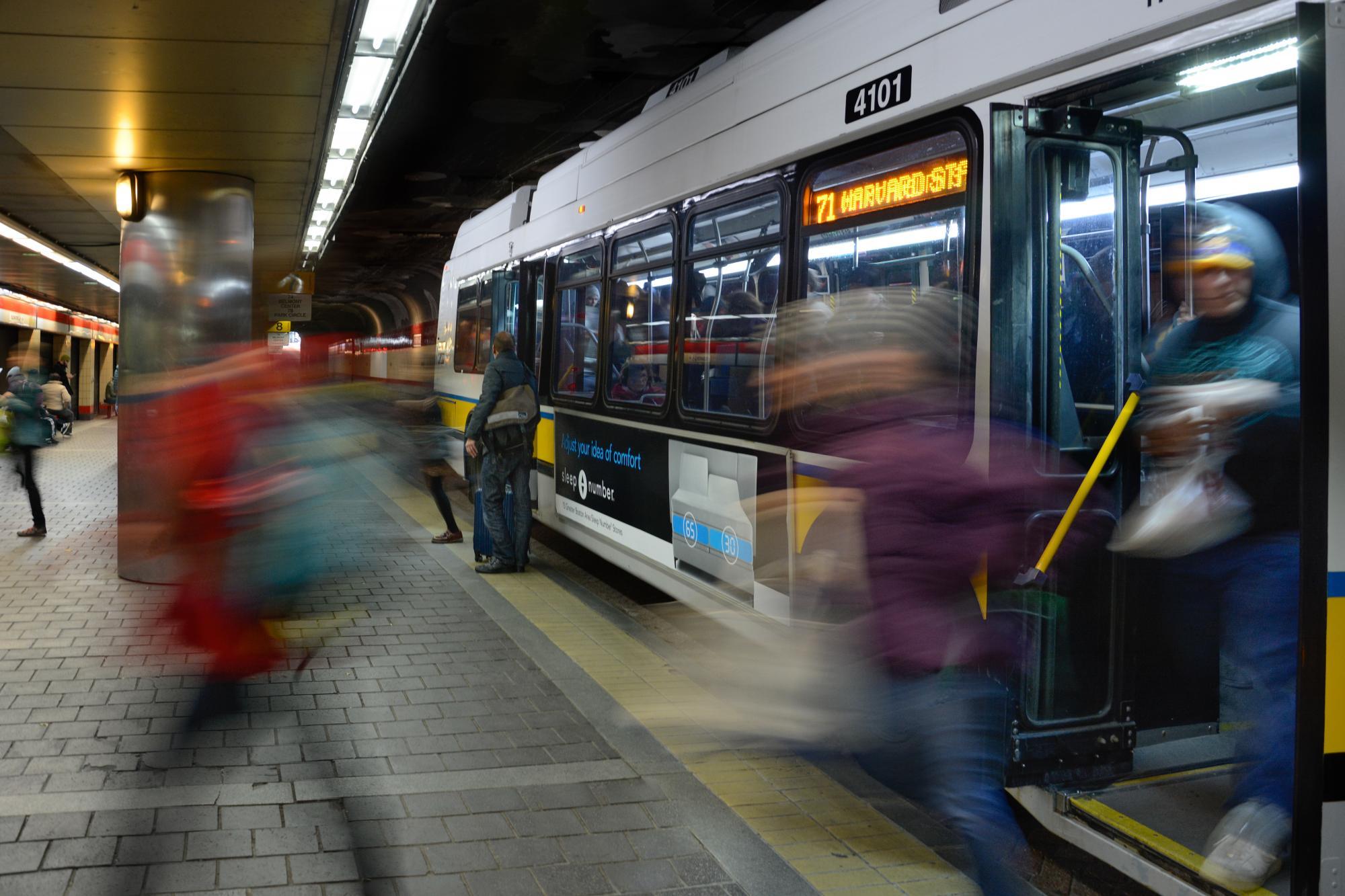 Riders enter and exit a bus in Harvard Station's Upper Busway