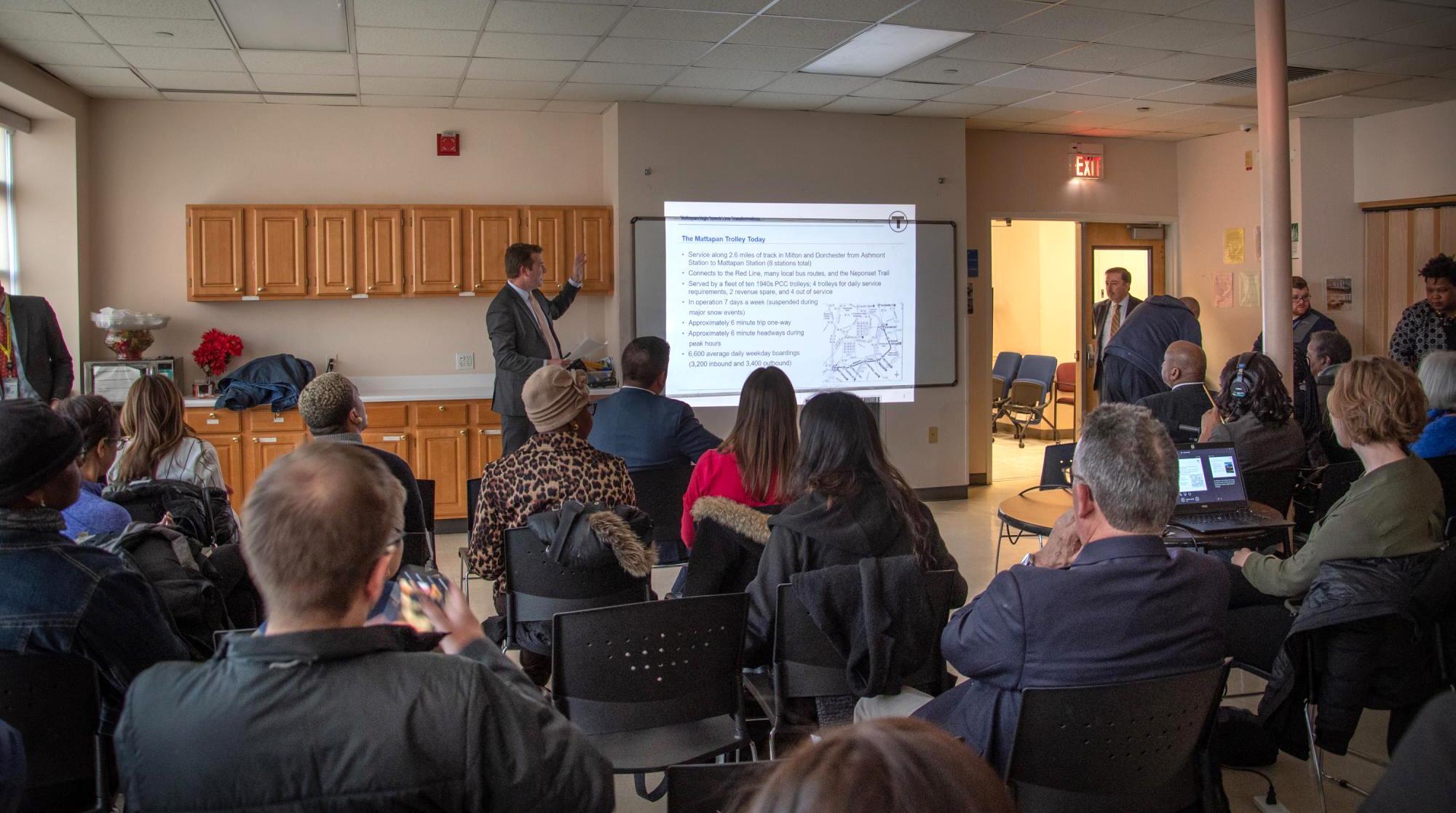 Community members listen to an MBTA presentation on the Mattapan Line Transformation