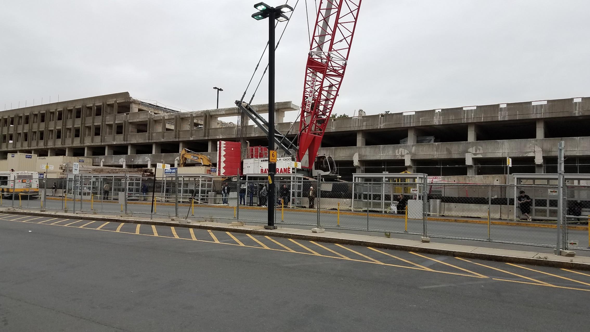 A crane in front of the Quincy Center garage during its demolition