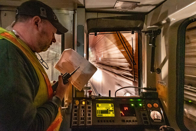 An MBTA personnel communicating via radio while in the cab of a train