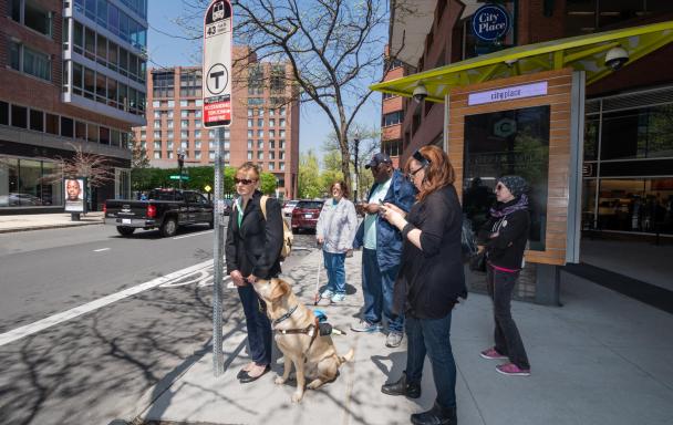 customers waiting at bus stop with guide dog
