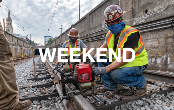Overlaid text reads "Weekend." A crew wearing face coverings, safety vests, and helmets works on rail.